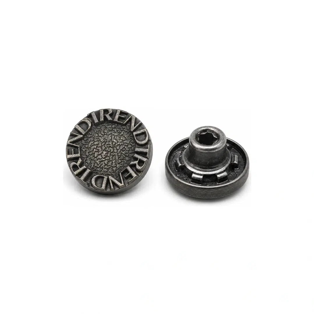 Antique silver raised-letter jeans button shown from the front and back