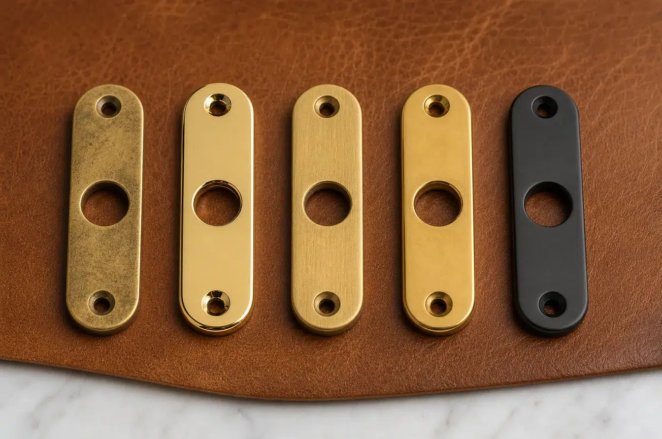 five brass hardware plates comparing patina polished brushed lacquered and PVD finishes