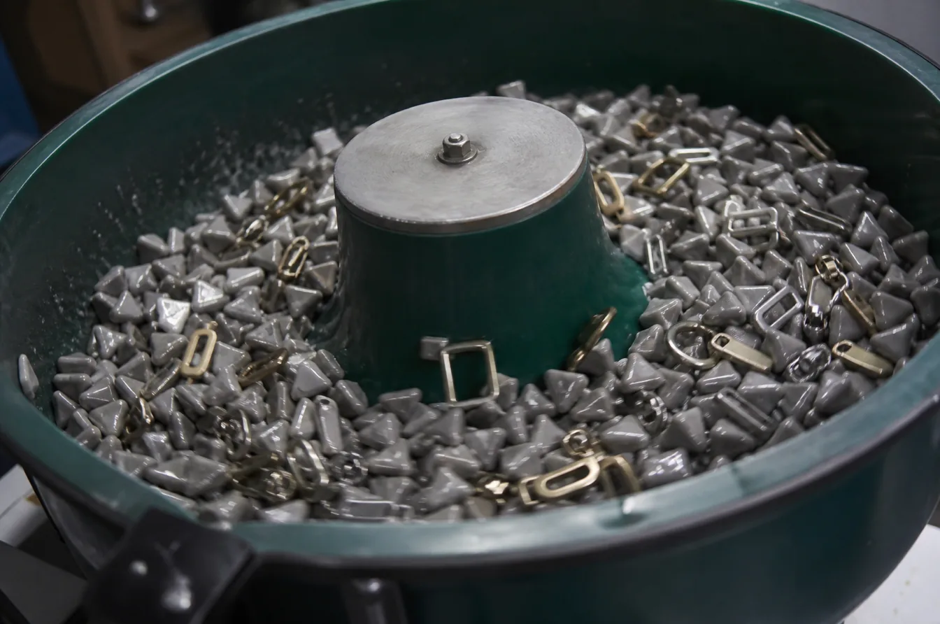 Custom fashion hardware and finishing media inside a vibratory tumbling machine